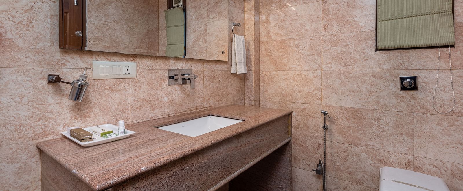 Washroom of the deluxe room featuring premium toiletries and a sleek wash basin.
